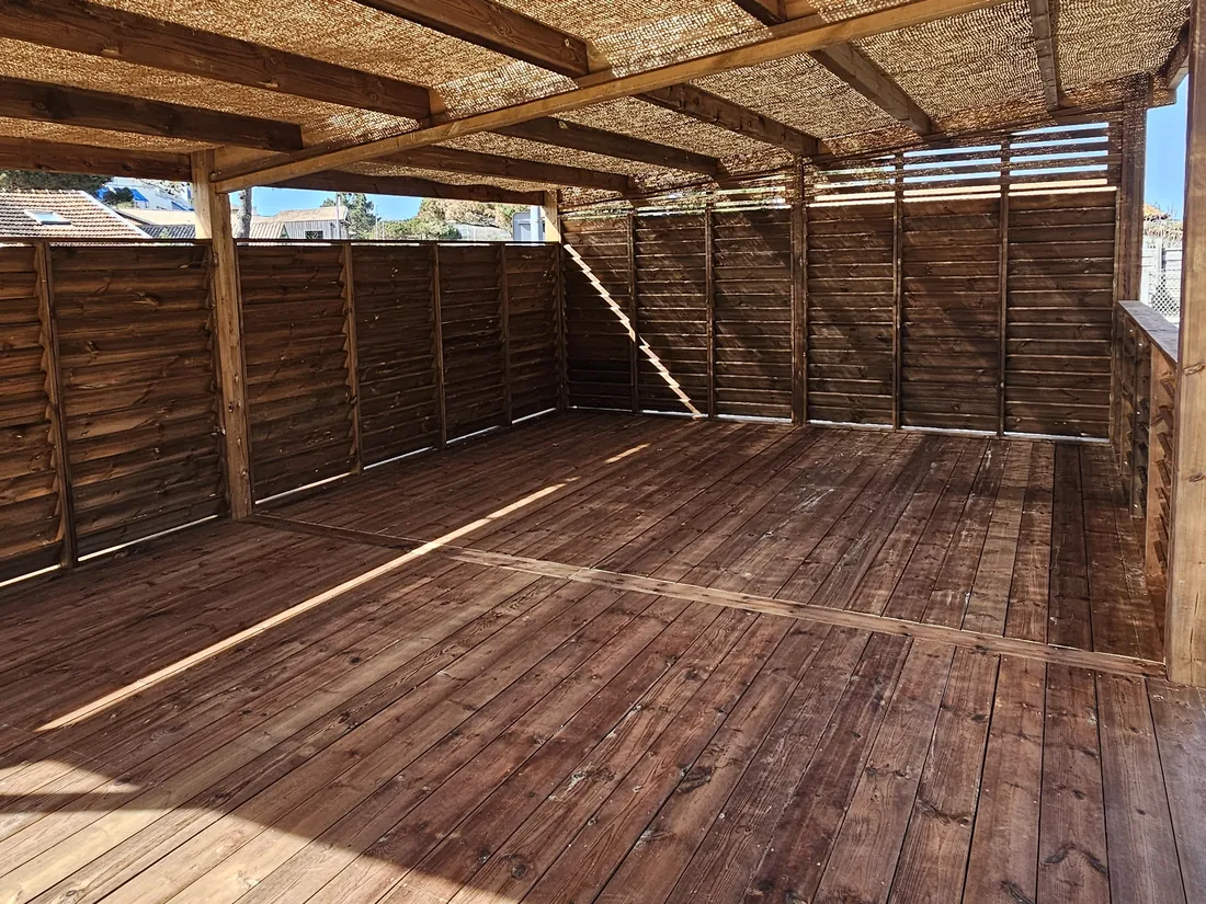 Plancher bois sous la couverture en canisse, entre claustras et pergola