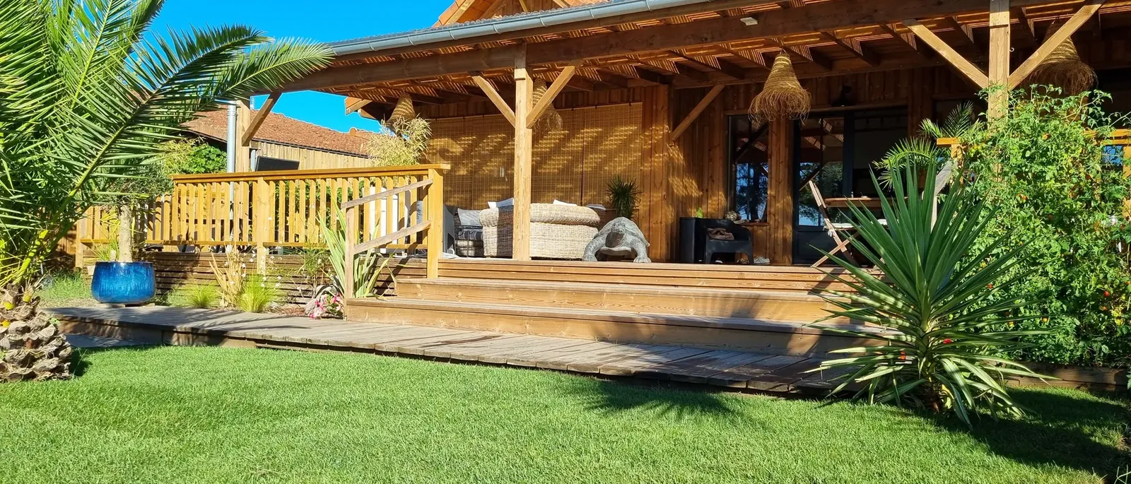 Terrasse couverte et pergola bois ouvrant sur un jardin planté