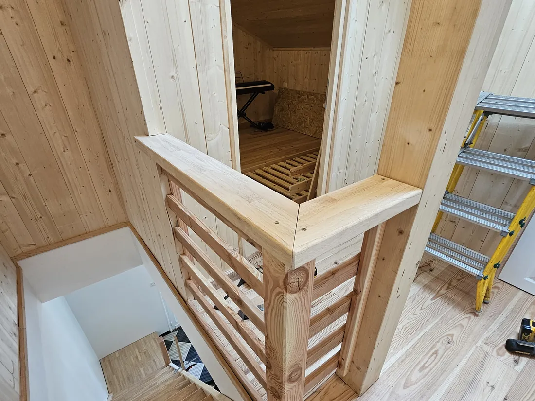 Trémie d’escalier habillée de bois clair, garde-corps à barreaux